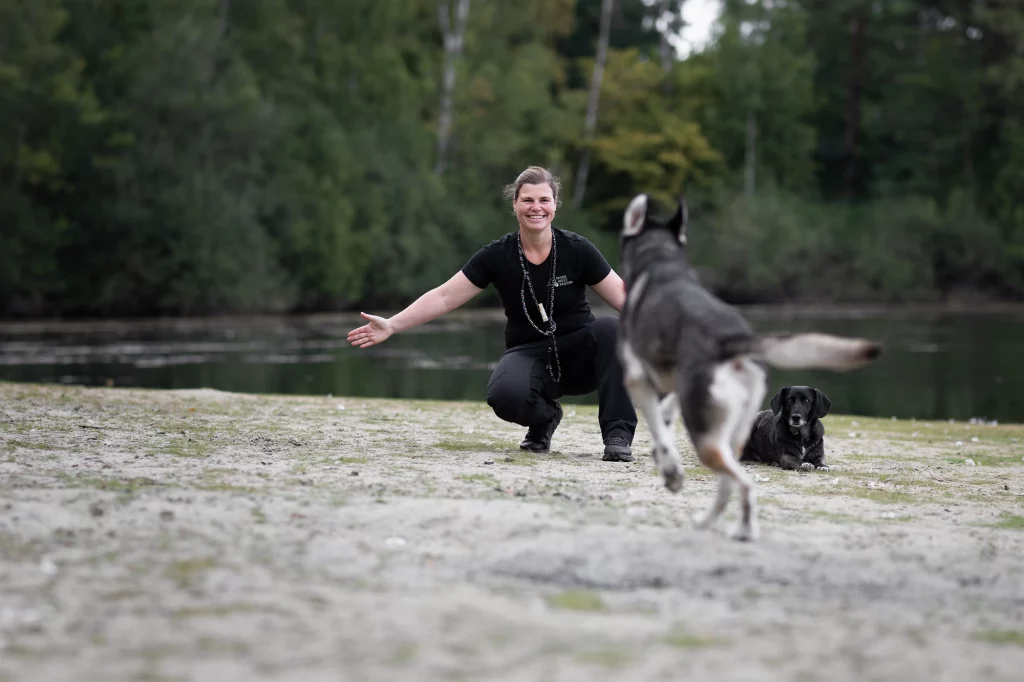 Business-Shooting in Münster: Hundetrainerin Tamara begrüßt einen Hund am Seeufer.