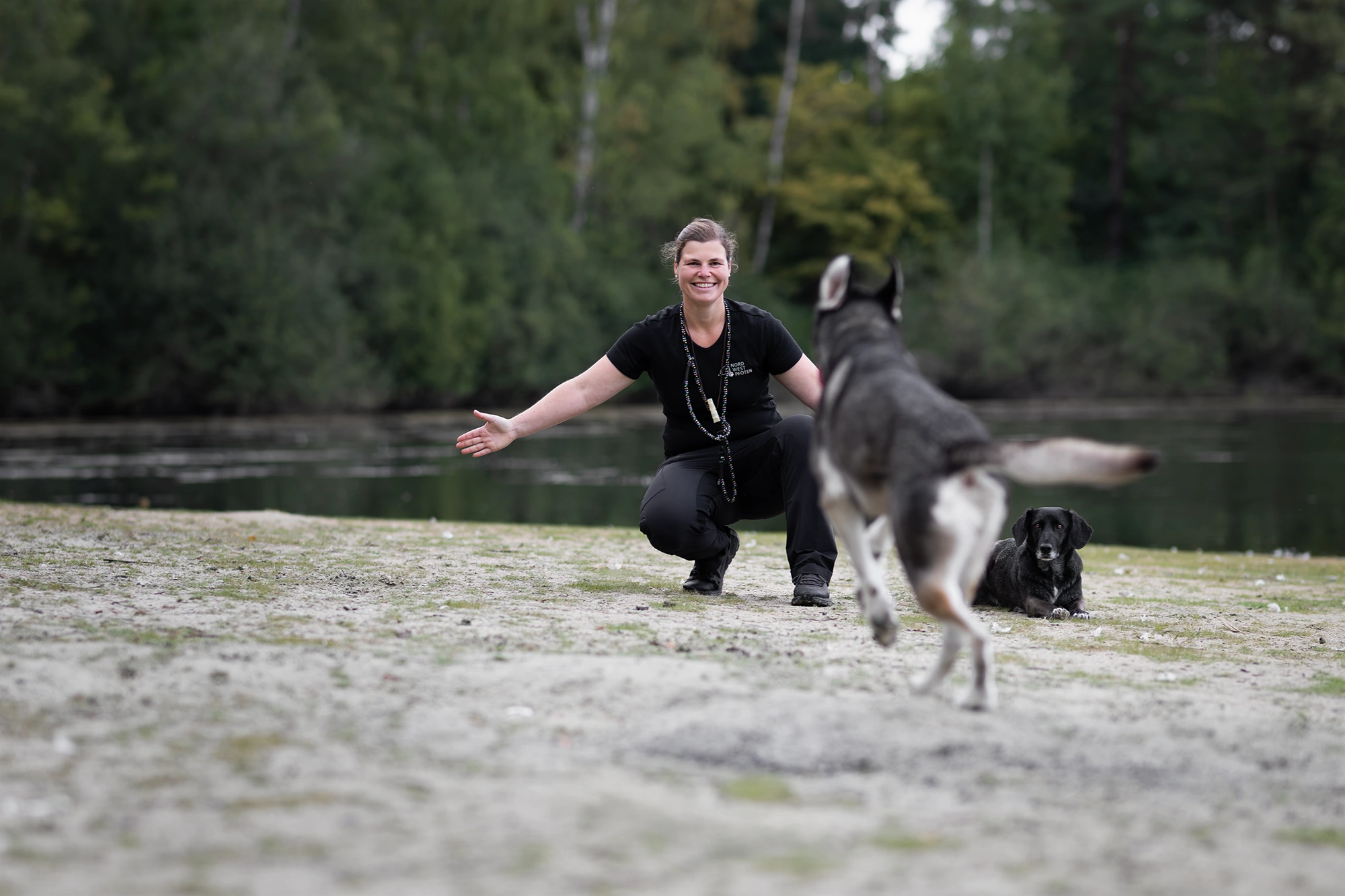 Business-Shooting in Münster: Hundetrainerin Tamara begrüßt einen Hund am Seeufer.